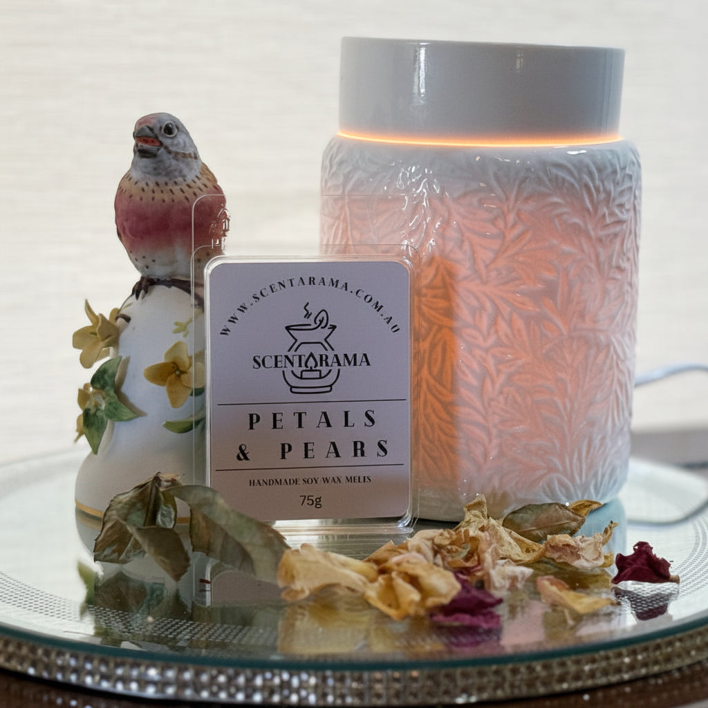 Petals and Pears Soy Wax Melts on a mirror tray with a Botanical Wax Melt Warmer and a bird trinket and dried petals