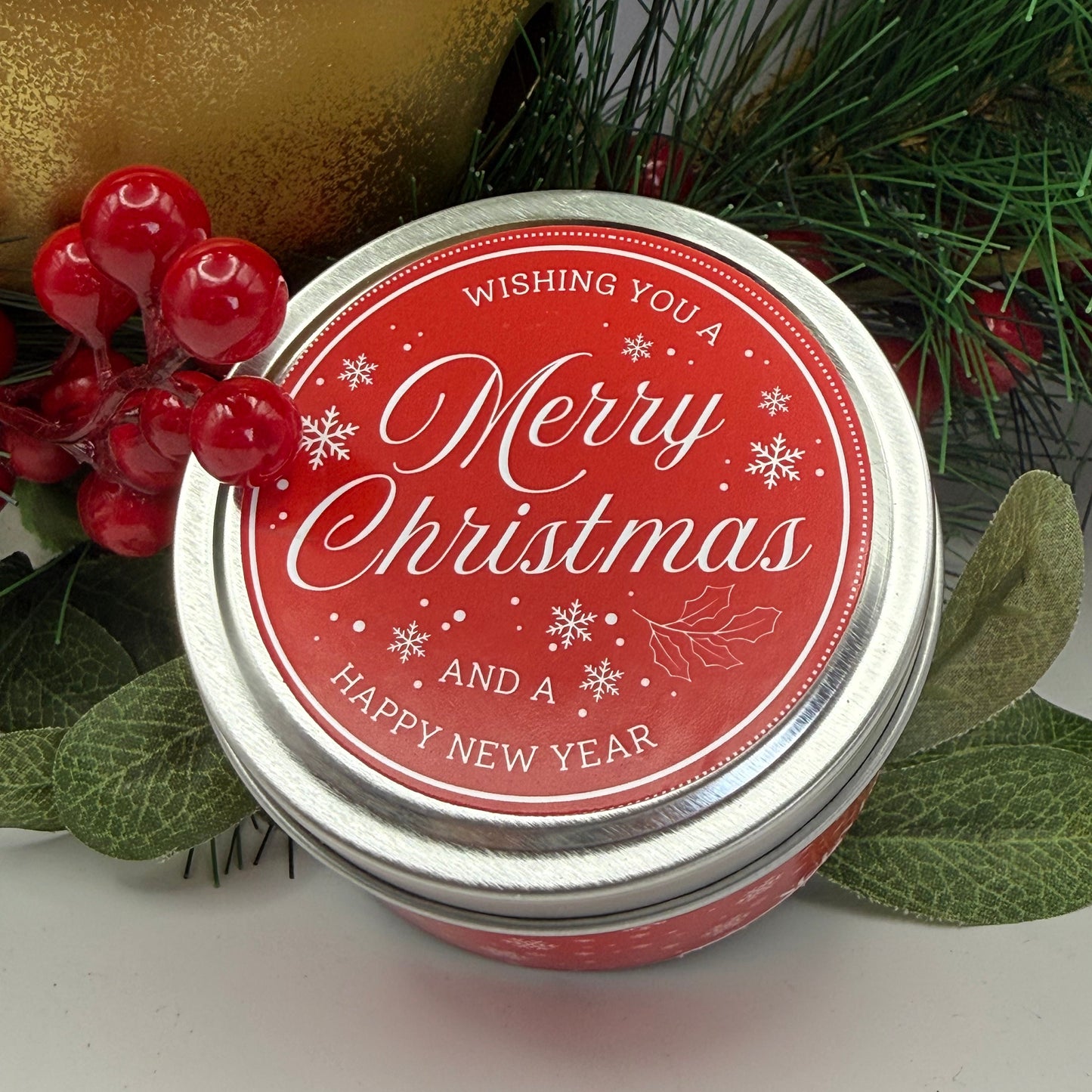 A silver candle travel tin decorated in a Christmas themed label 