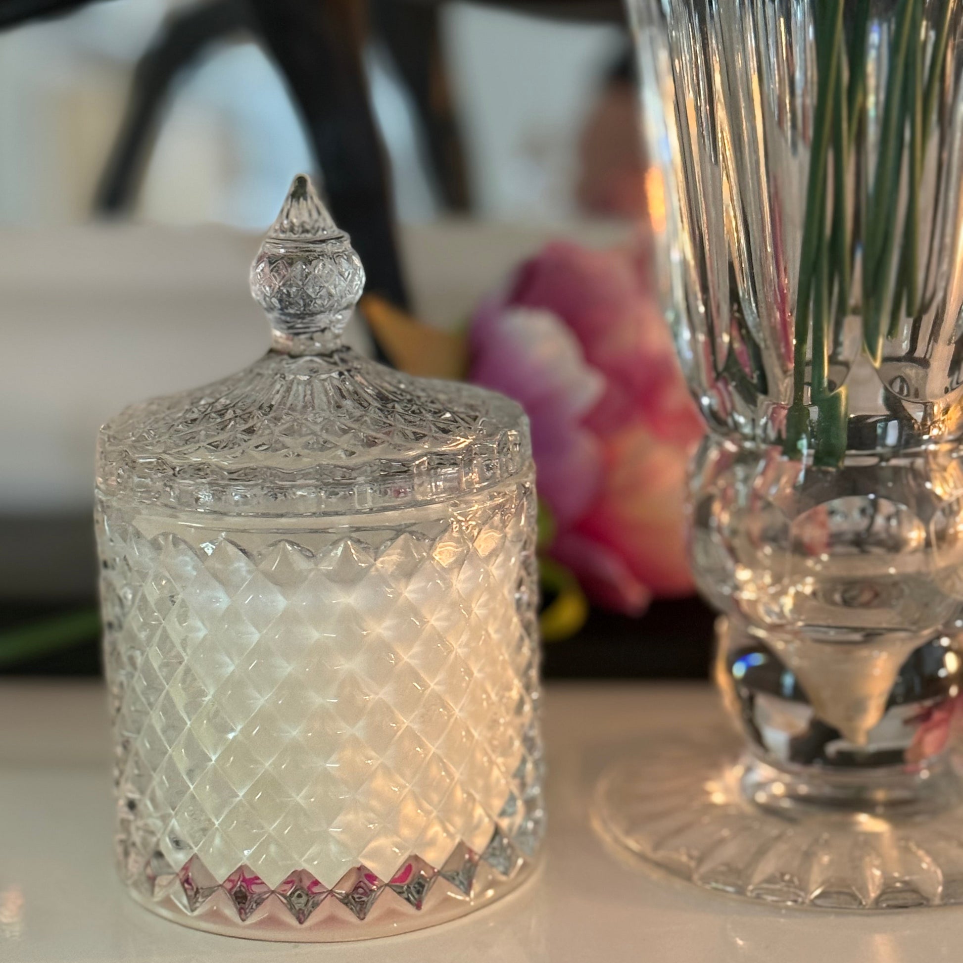 Decorative glass candle container with a lid on a table
