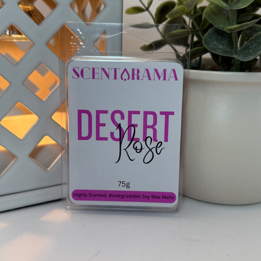 A package of Scentarama Desert Rose soy wax melts, 75g, displayed on a white surface with a decorative white lattice screen and a potted green plant in the background.