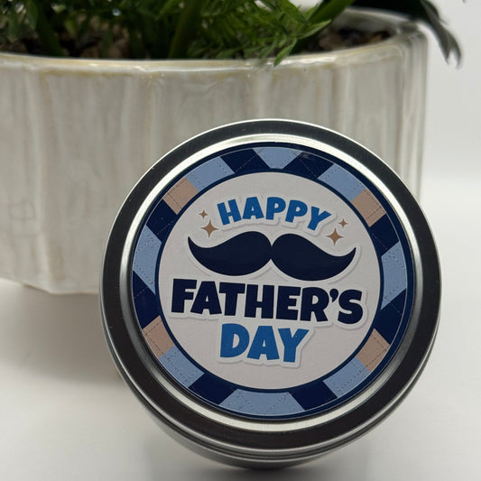 Fathers Day Travel Candle in Amberered Sandalwood Scent by Scentarama resting on a potted plant on white background