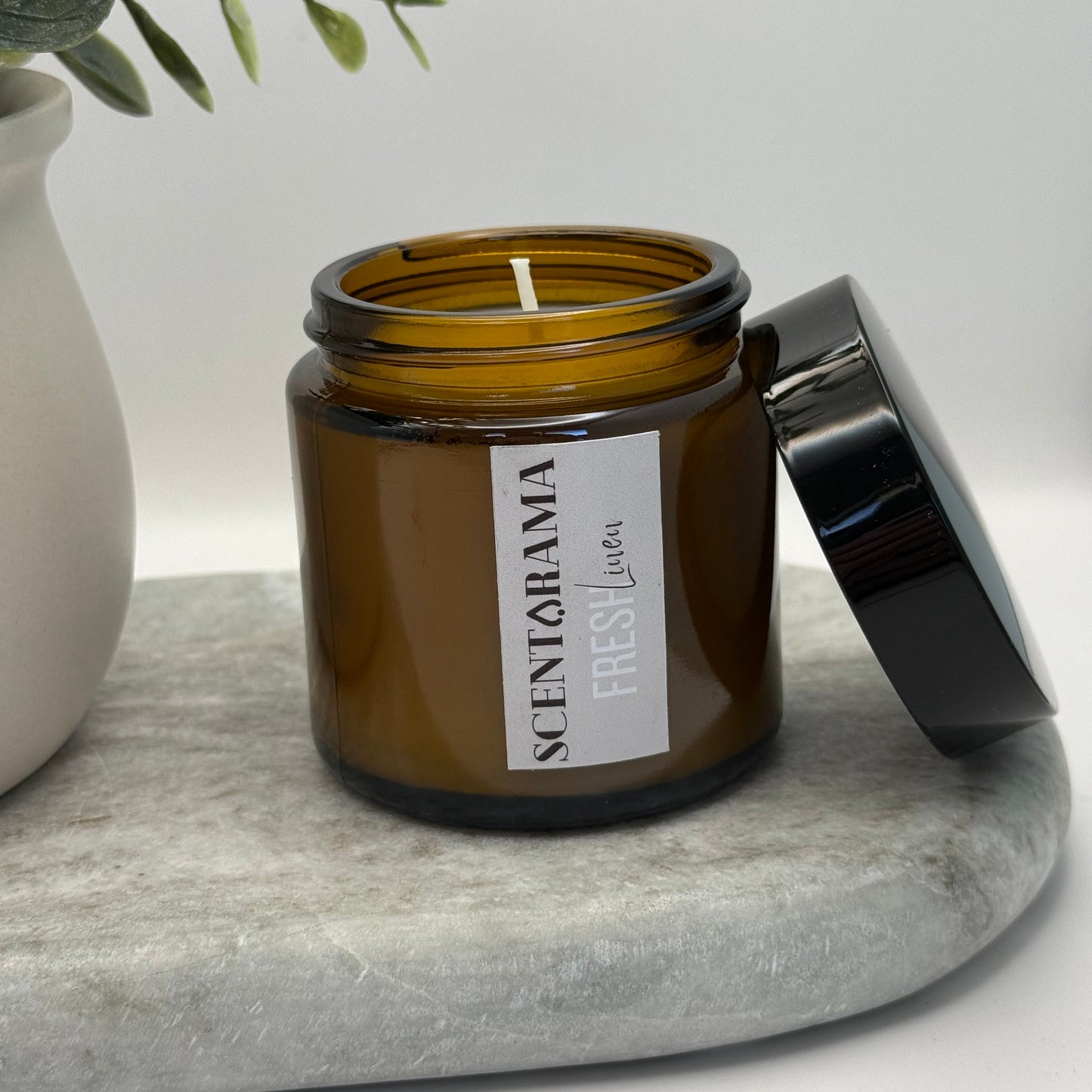 Small Amber Jar Candle in Fresh Linen Scent on a marble tray 