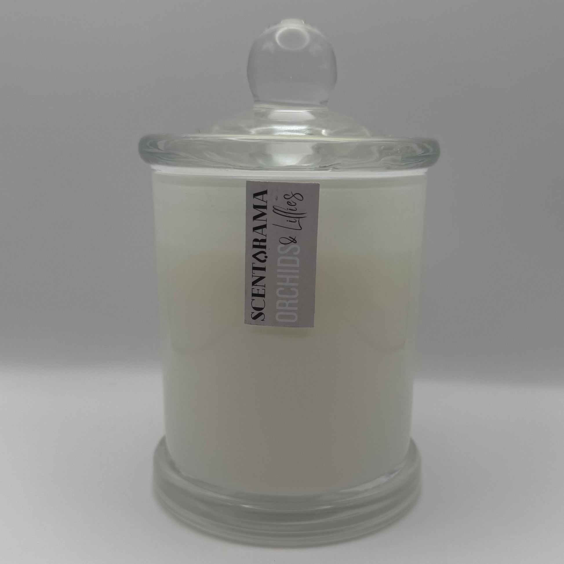White candle in a glass jar with a label on a white background