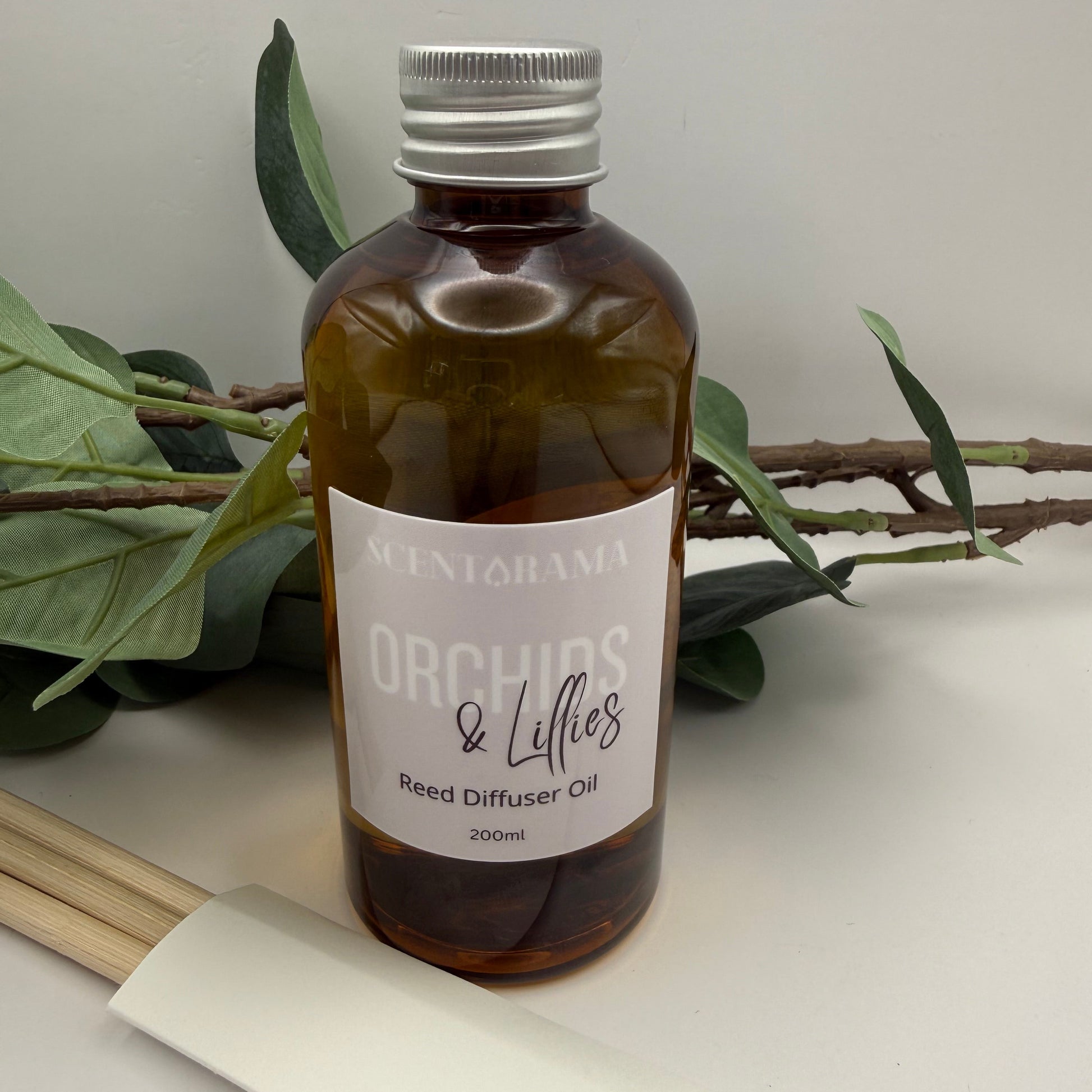 Brown bottle with a label on a white surface with green leaves