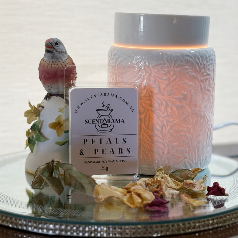 Petals and Pears Soy Wax Melts on a mirror tray with a Botanical Wax Melt Warmer and a bird trinket and dried petals