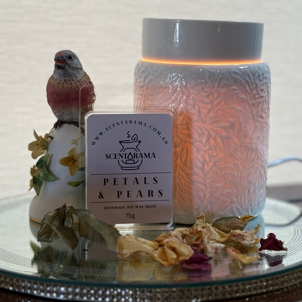 Petals and Pears Soy Wax Melts on a mirror tray with a Botanical Wax Melt Warmer and a bird trinket and dried petals