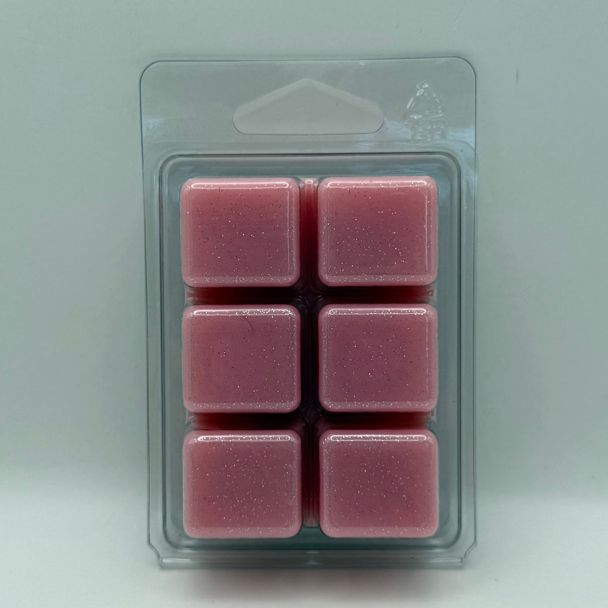 Six pink Scentarama wax melts Unicorn Puff Scented in a clear plastic clamshell package on a light white background.