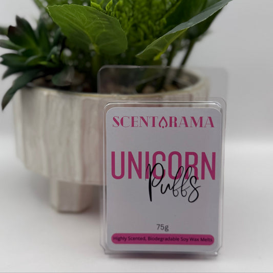 A 75g pack of Scentarama 'Unicorn Puffs' soy wax melts in a clear plastic clamshell container, set against a white background with a decorative potted green plant behind it.