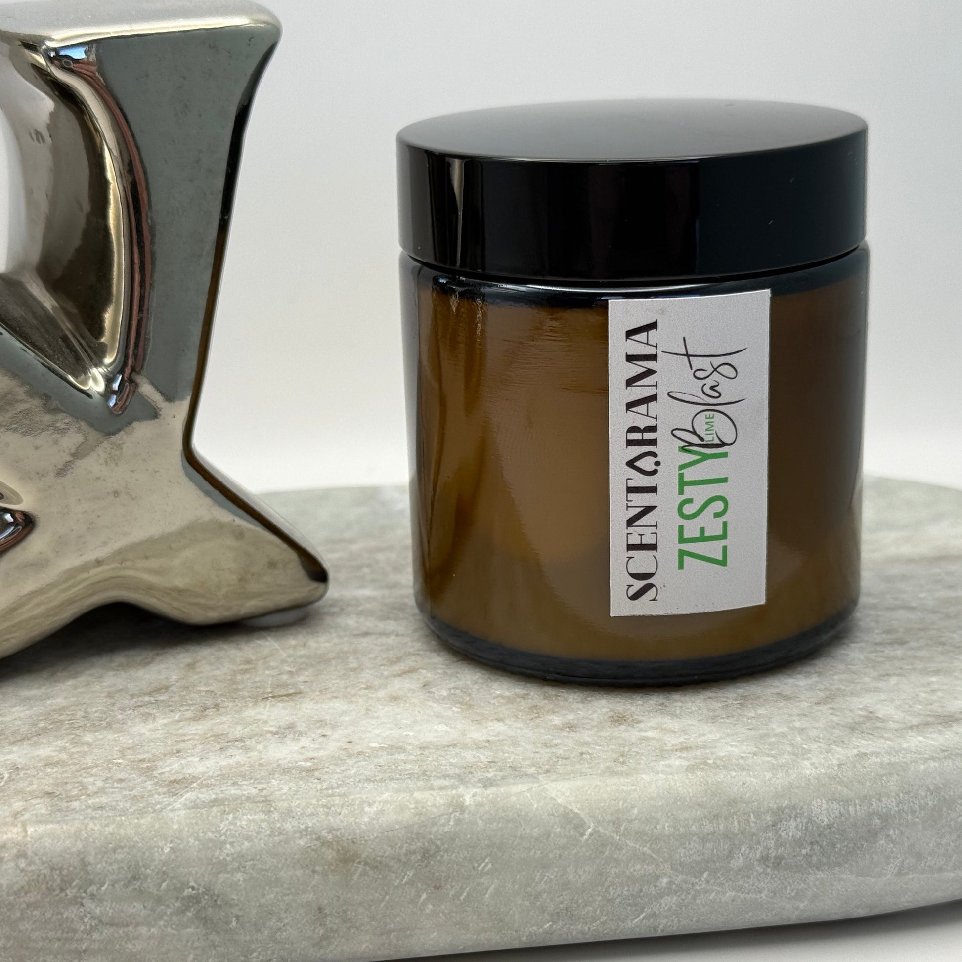 Zesty Lime Blast Candle jar featuring a Scentarama label on a marble surface next to a decorative object.